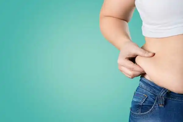 Image of woman pinching her love handles to show weight gain Gosport